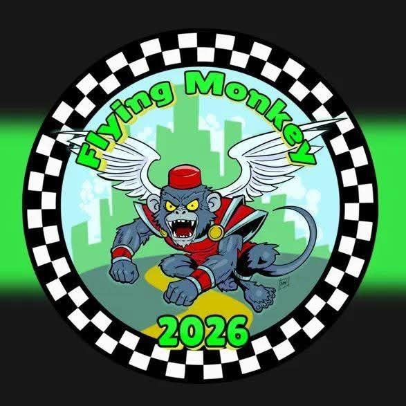  Circular “Flying Monkey” 2026 emblem with a fierce winged superhero monkey, city skyline, checkerboard border, and vivid green glow. 